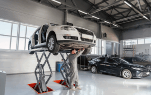 Mecánico revisando el motor de un coche en un taller mecánico auto profesional.