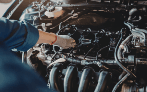 Mecánico trabajando en un coche Mitsubishi en un taller especializado, asegurando la calidad y el buen funcionamiento del vehículo.